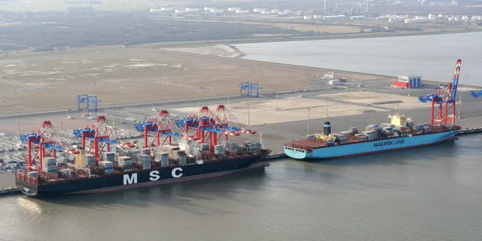 A MSC ship beside a smaller Maersk ship.