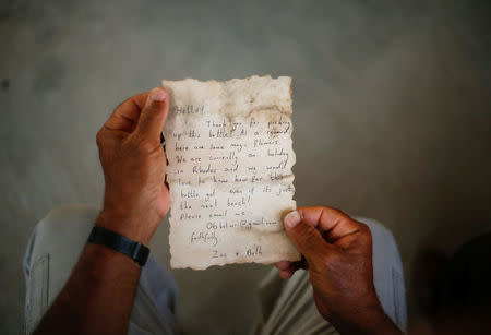 Palestinian fisherman Jihad al-Soltan displays a message that was written by Bethany Wright and her boyfriend Zac Marriner, after he found it in a bottle off a Gaza beach, in Gaza August 21, 2017. REUTERS/Mohammed Salem