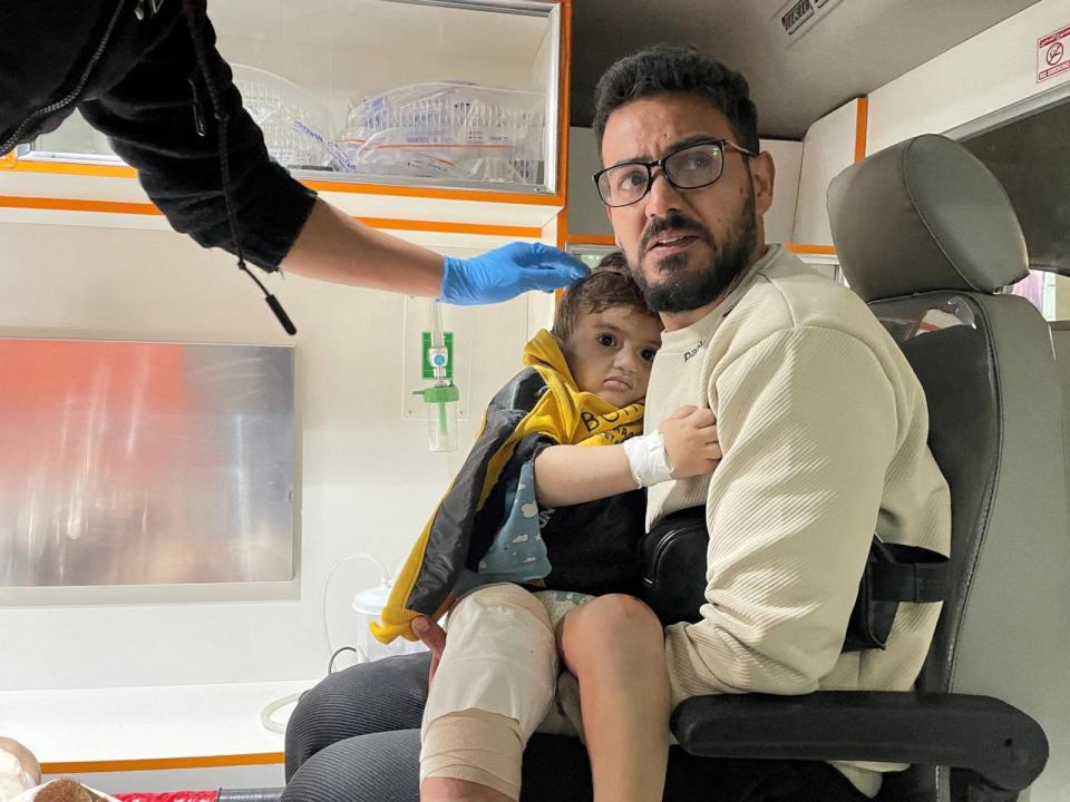 PHOTO: A Palestinian man carrying a child wounded in an Israeli strike sits inside an ambulance as they are rushed into a hospital in Rafah, in the southern Gaza Strip, Feb. 12, 2024.  (Shadi Tabatibi/Reuters)