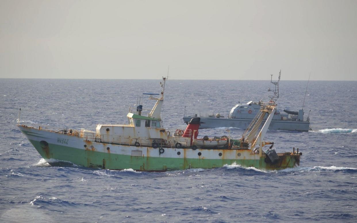 The Italian fishing boat Aliseo was fishing north of the Libyan coast when it was hit by shots fired by a Libyan patrol vessel, seen in the background - MarinaMilitare/DAPRESS / SplashNews.com