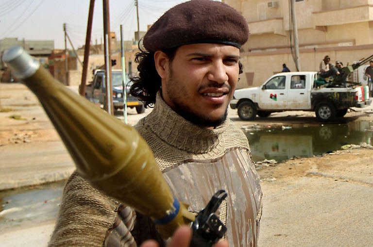 A Libyan rebel, known by his comrades as "Che" for his resemblance to revolutionary leader Ernesto Che Guevara, guards an area with his colleagues near the western gate of Ajdabiya. Libyan regime forces pounded rebels with heavy artillery west of Ajdabiya, forcing hundreds of residents and some fighters to flee the key crossroads town, as a refugee rescue operation in Misrata was under way