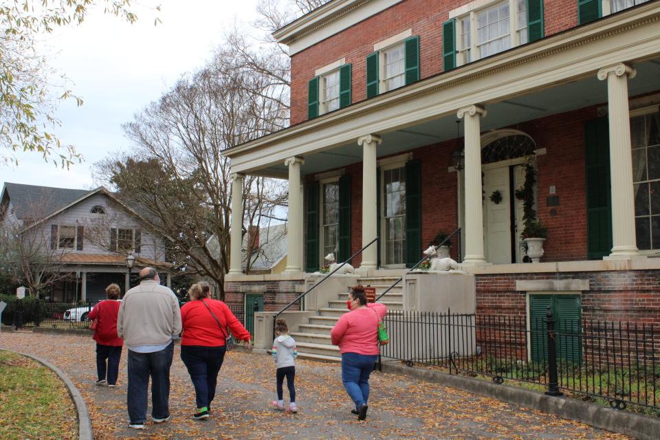 A family walks in front of the Centre Hill Mansion on their way to attend the PPTF Christmas open house in Petersburg on Dec. 5, 2020.