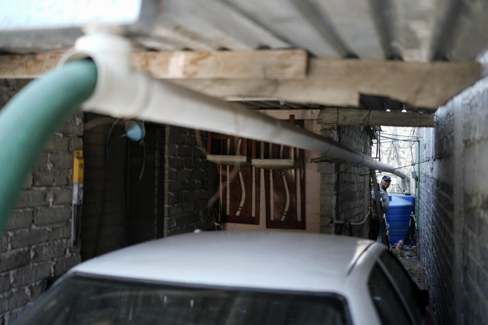 A water truck hose placed into an elongated drain pipe transports water into an industrial pail for a resident in the Iztapalapa neighborhood of Mexico City, Wednesday, March 6, 2024. As the election approaches, a worsening water crisis is making it harder for the presidential candidates to ignore Mexico’s climate threats. (AP Photo/Eduardo Verdugo)