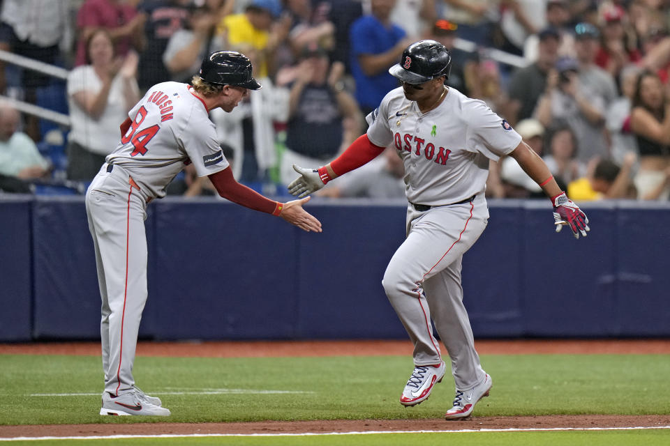 Boston Red Sox's Rafael Devers celebrates with third base coach Kyle Hudson (84) after his two-run home run off Tampa Bay Rays starting pitcher Taj Bradley during the fourth inning of a baseball game Monday, May 20, 2024, in St. Petersburg, Fla. (AP Photo/Chris O'Meara)