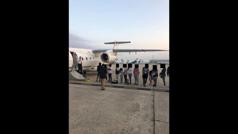 Migrantes con los rostros oscurecidos afuera del avión que los transportó de Texas a Martha's Vineyard, Massachusetts. Los contribuyentes de la Florida pagaron el chárter.