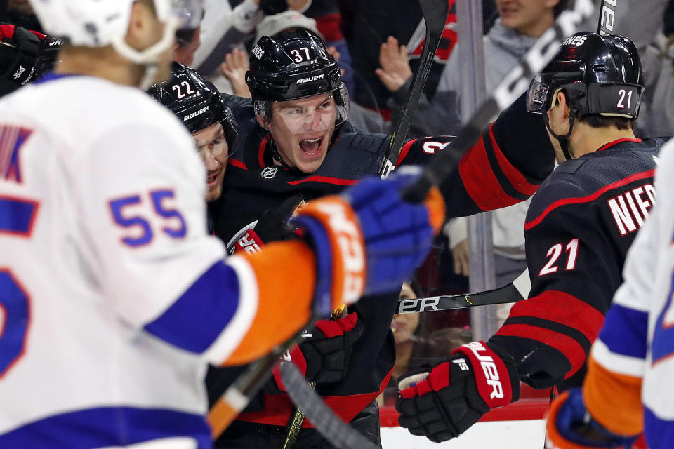 Carolina Hurricanes' Andrei Svechnikov (37), of Russia, celebrates his goal against the New York Islanders with teammates Brett Pesce (22) and Nino Niederreiter (21), of Switzerland, during the first period of an NHL hockey game in Raleigh, N.C., Sunday, Jan. 19, 2020. (AP Photo/Karl B DeBlaker)