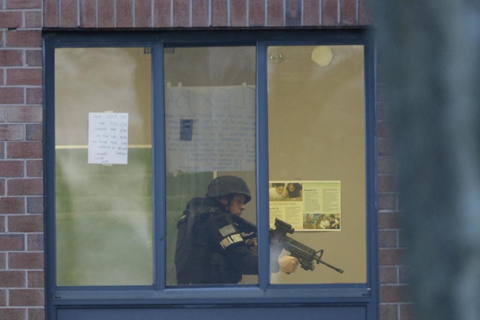 Police search at the Delaware Valley Charter School Friday, Jan. 17, 2014, in Philadelphia after two students were shot by another student. A boy hanging out in the high school gym with fellow students on Friday afternoon shot and wounded two of them before fleeing and being captured near his home, police said. A male student and a female student were shot, each in an arm. The wounded students were taken to a hospital near the school, where they were listed in stable condition, police said. (AP Photo/Matt Rourke)