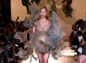 <p>Auch bei Iris van Herpen traf Kunst auf Mode. Hierfür ließ sich die Designerin von der Natur inspirieren. Ein Model schickte sie in einem außergewöhnlichen Minikleid über den Laufsteg, das mit welligen Formen an wildes Gewässer erinnerte. Entstanden ist das Outfit übrigens in einem 3-D-Drucker. (Bild: Getty Images) </p>