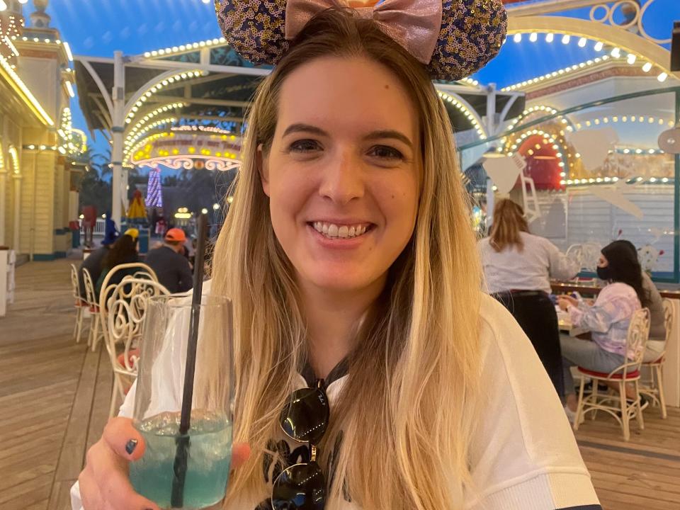 carly holding a drink and wearing minnie ears at lamplight lounge
