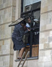 Civilians flee through a window at a hotel complex in Nairobi, Kenya Tuesday, Jan. 15, 2019. Terrorists attacked an upscale hotel complex in Kenya's capital Tuesday, sending people fleeing in panic as explosions and heavy gunfire reverberated through the neighborhood. (AP Photo/Ben Curtis)