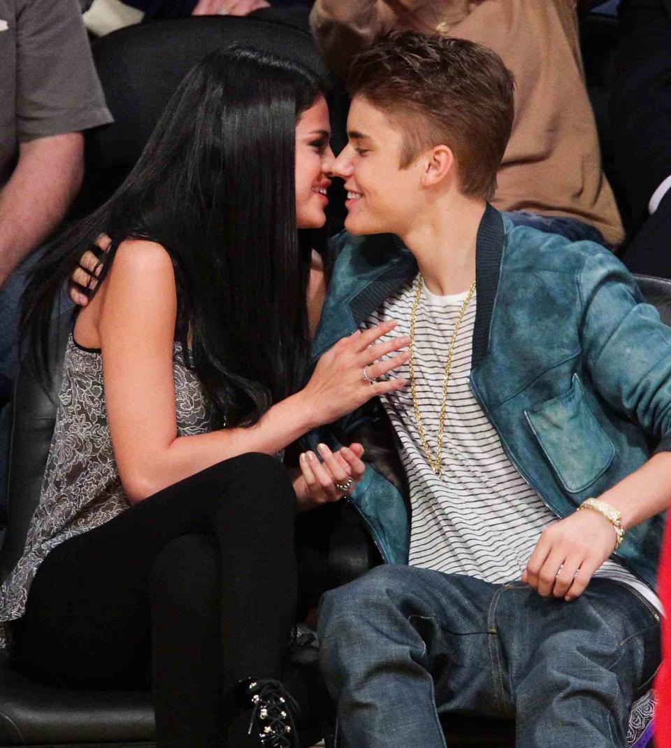 Selena Gomez (L) and Justin Bieber kiss at a basketball game between the San Antonio Spurs and the Los Angeles Lakers at Staples Center on April 17, 2012 in Los Angeles, California