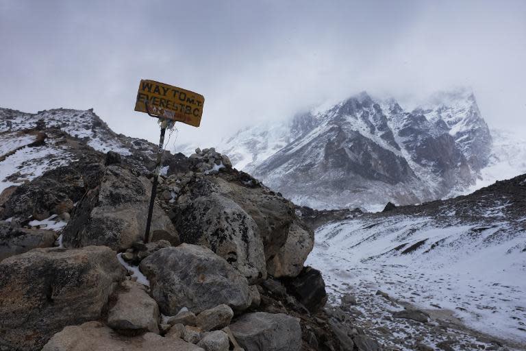 A sign showing the way to Everest Base Camp high in the Khumb Glacier stands among rocks on April 26, 2015