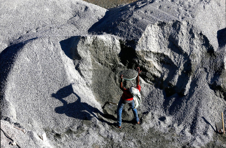 A laborer lifts a tub of sand and cement in Bangalore, India