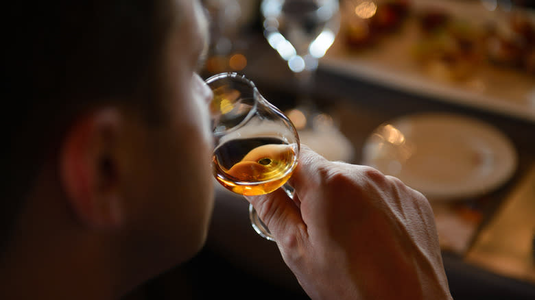 person sniffing bourbon glass