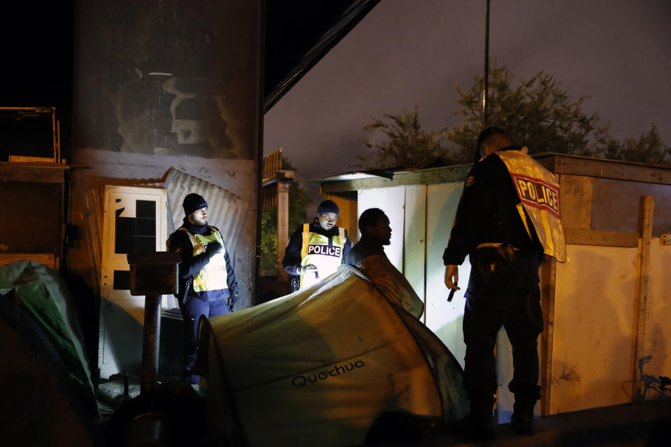 Policía francesa desaloja a un migrante durante un operativo para desmantelar un campo de migrantes improvisado en el norte de París, el jueves 7 de noviembre de 2019. (AP Foto/François Mori)