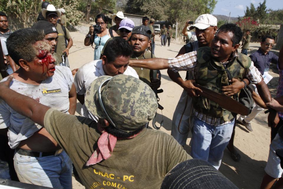 Community policemen take away men suspected of participating in an ambush against them near the town of La Concepcion, Mexico, Friday April 4, 2014. The vigilante force was set-up by affected communities who created the Council of Communal Land Owners and Communities Against the Construction of La Parota Dam (CECOP), opposed to the construction of the La Parota hydroelectric dam. Two vigilantes were injured and one died. At least four suspects were later detained. (AP Photo/Bernandino Hernandez)