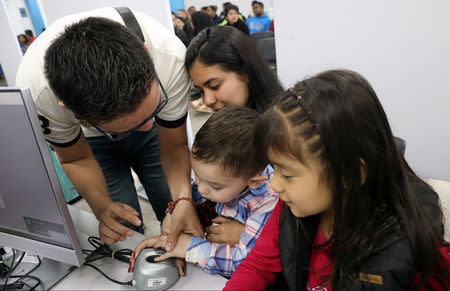 Venezuelan migrant family stamp their fingerprints to get their temporary residency permit at the immigration office in Lima, Peru August 20, 2018. REUTERS/Mariana Bazo