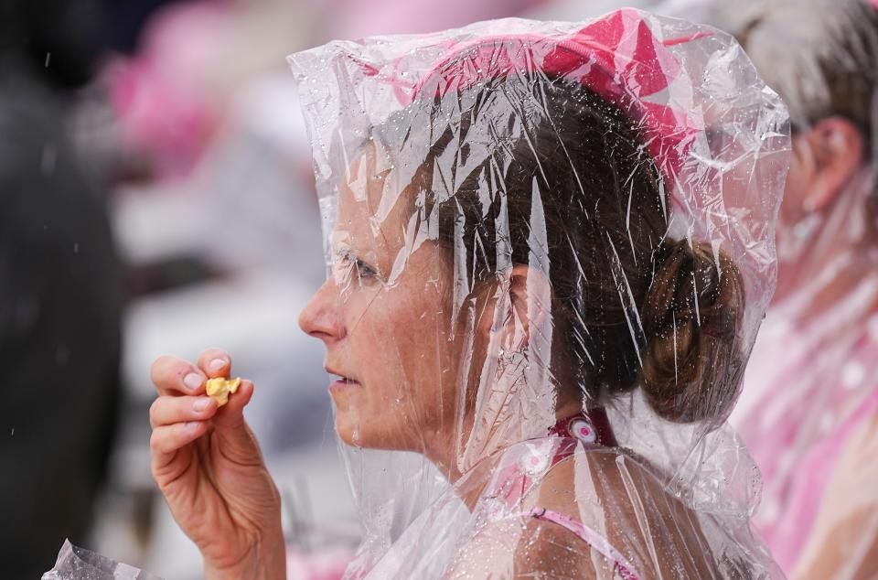 Racing fans walk through the rain during the 148th running of the Kentucky Oaks on Friday, May 6, 2022, at Churchill Downs in Louisville, Kentucky. 