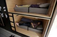 Wu Binbin (bottom) and Chen Huiyang, employees at BaishanCloud, take a nap after lunch in individual sleeping quarters, in the office, in Beijing, China, April 26, 2016. REUTERS/Jason Lee