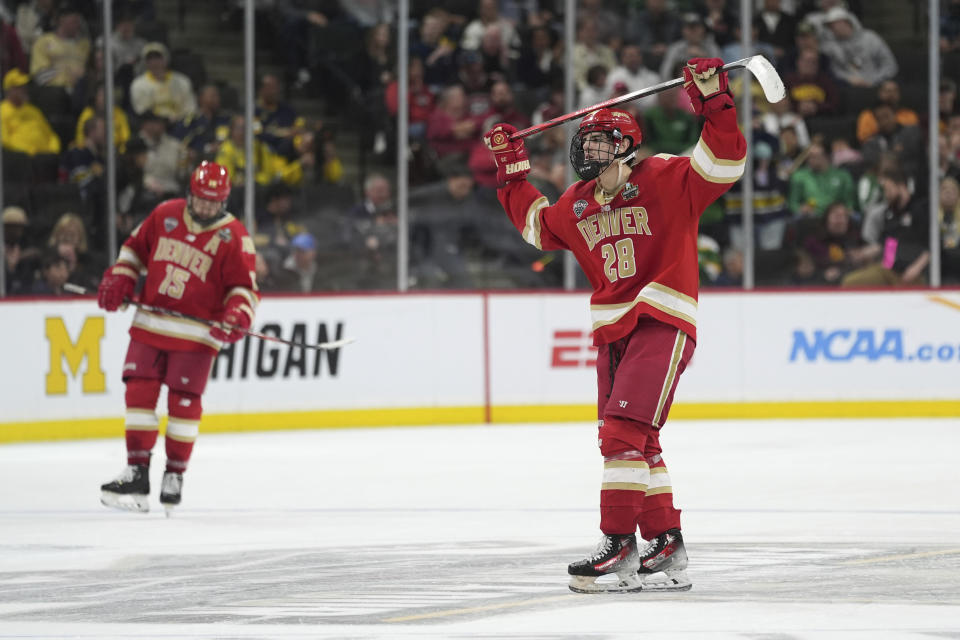Denver forward Carter King (15) and defenseman Zeev Buium (28) skate as time expires to end a semifinal game against Boston University at the Frozen Four NCAA college hockey tournament Thursday, April 11, 2024, in St. Paul, Minn. (AP Photo/Abbie Parr)