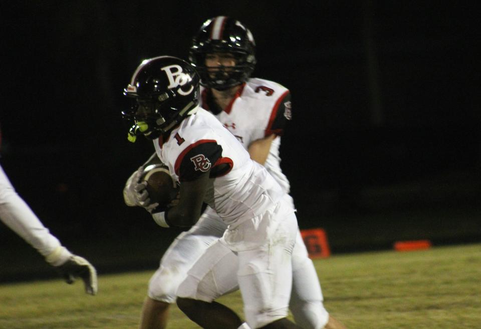 Baker County's Cam Smith takes a handoff in a game against Jackson.