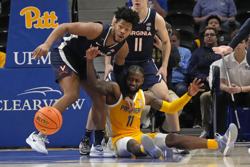Pittsburgh guard Jamarius Burton (11) loses control of the ball with Virginia forward Jayden Gardner, left, and guard Isaac McKneely (11) defending during the first half of an NCAA college basketball game in Pittsburgh, Tuesday, Jan. 3, 2023. (AP Photo/Gene J. Puskar)