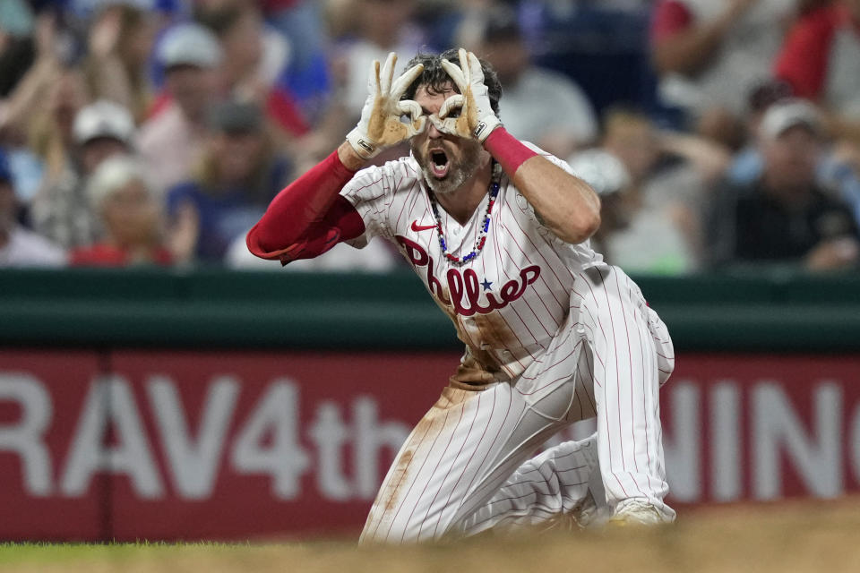 Philadelphia Phillies' Jake Cave reacts after hitting a run-scoring triple against Atlanta Braves pitcher Kyle Wright during the fourth inning of the second baseball game in a doubleheader, Monday, Sept. 11, 2023, in Philadelphia. (AP Photo/Matt Slocum)