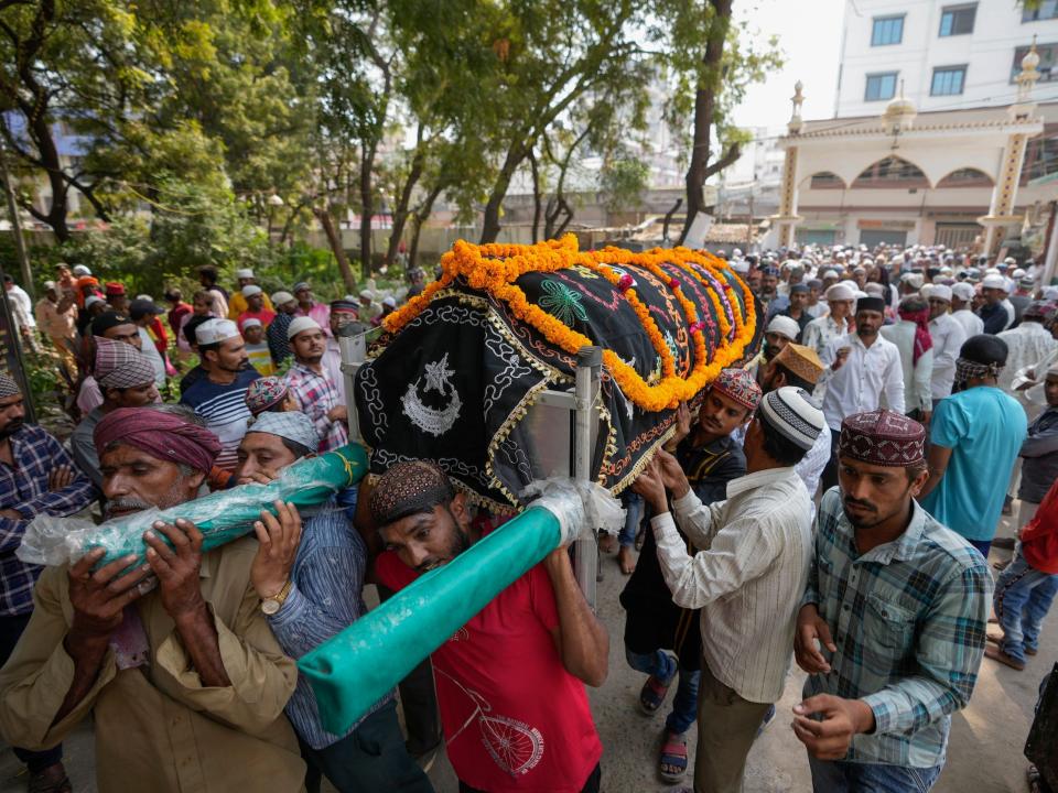 People prepare to cremate the body of a victim of a pedestrian bridge collapse in Morbi town