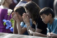 A woman prays at the edge of the North Pool at the 9/11 Memorial during a ceremony marking the 12th anniversary of the 9/11 attacks on the World Trade Center in New York September 11, 2013. (REUTERS/Justin Lane)