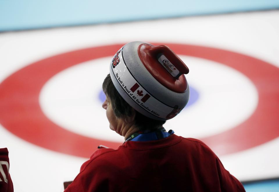 Fan of Canada wearing a hat in the shape of a stone looks on during their men's curling round robin game against Germany at the 2014 Sochi Olympics