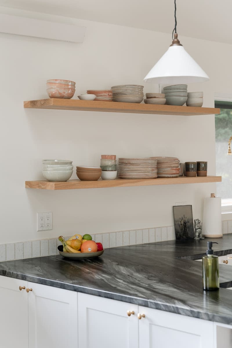 Ceramic dish ware displayed on open kitchen shelving.