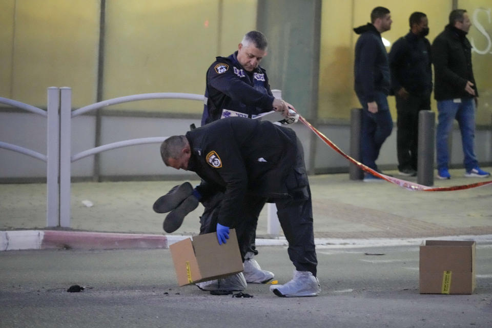 Policemen work at the scene of an attack in Beersheba, Southern Israel, Tuesday, March 22, 2022. A knife-wielding Arab man killed several people and seriously wounded others in the southern Israeli city of Beersheba, a rampage officials called a terror attack with nationalist motives. (AP Photo/Tsafrir Abayov)
