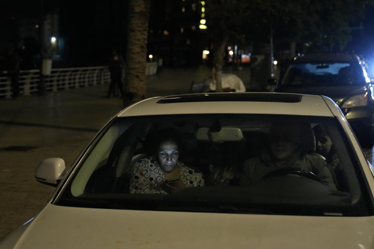 Following an earthquake that struck in neighboring Turkey, in Lebanon, in Beirut, Lebanon, a family sits in their car after fleeing their home early Monday, Feb. 6, 2023. Many residents in Lebanon left their homes or drove in their cars away from buildings. A powerful earthquake hit southeast Turkey and Syria early Monday, toppling buildings and sending panicked residents pouring outside in a cold winter night. (AP Photo/Hussein Malla)