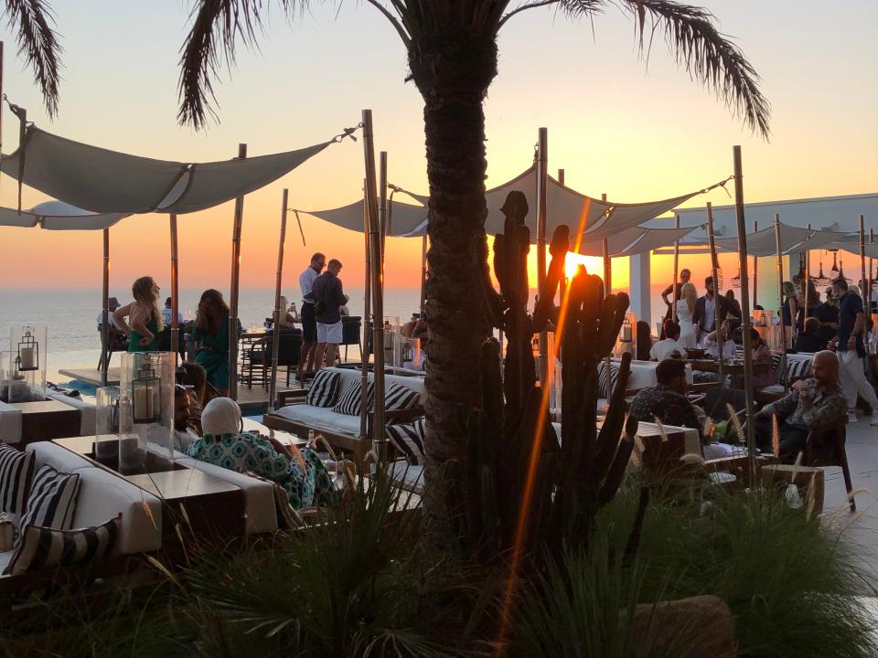 resort guests milling around oceanside bars and restaurants at cavo taggoo resort in greece