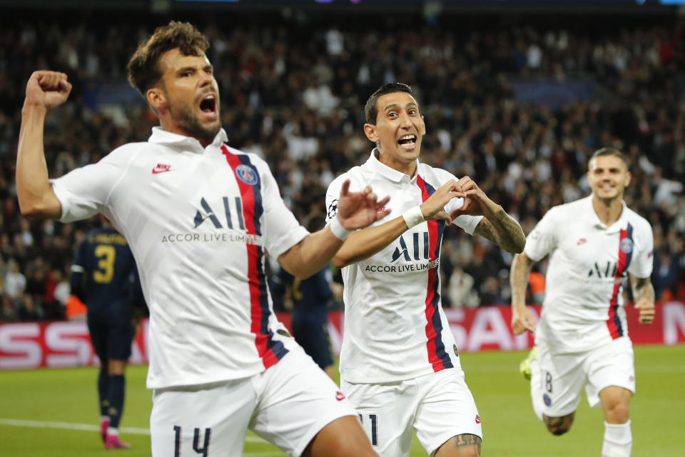 PSG's Angel Di Maria, center, celebrates with his teammates PSG's Juan Bernat, left, and PSG's Mauro Icardi after scoring his side's opening goal during the Champions League group A soccer match between PSG and Real Madrid at the Parc des Princes stadium in Paris, Wednesday, Sept. 18, 2019. (AP Photo/Francois Mori)