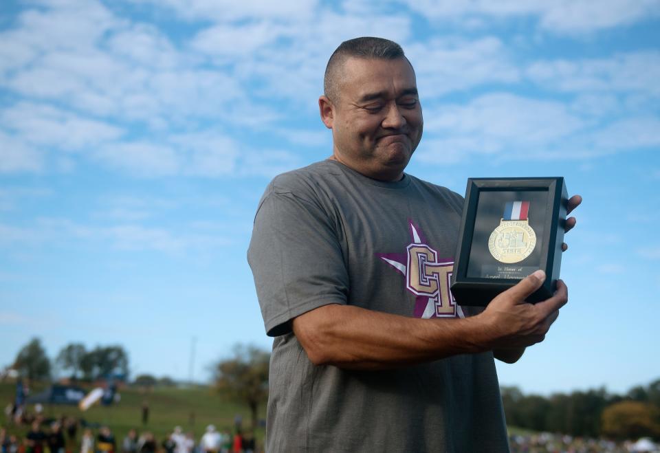 Antonio Hernandez accepts a UIL gold medal for his son, Angel, before the Region I-6A boys cross country meet, Tuesday, Oct. 24, 2023, at Mae Simmons Park. Angel, a Chisholm Trail cross country runner, died earlier this month after he collapsed after finishing a district cross country race.