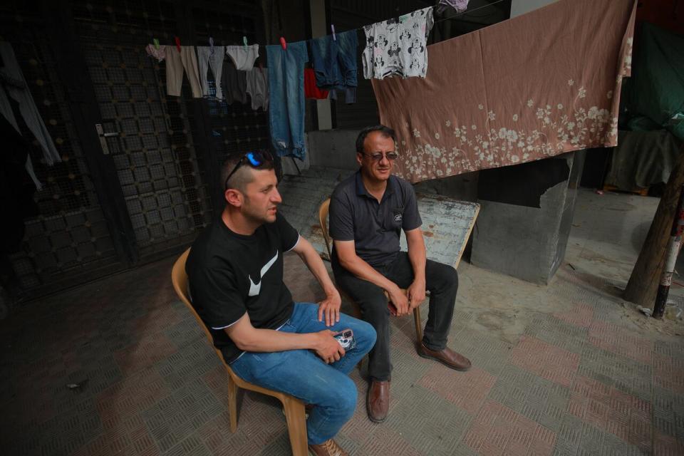Nael Al Masri (right) sits with an unidentified neighbour in his home in Deir el Balah.