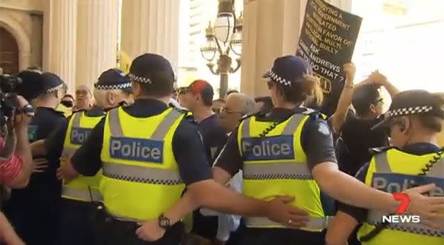 Police linked arms to stop protesters pushing through. Picture: 7 News