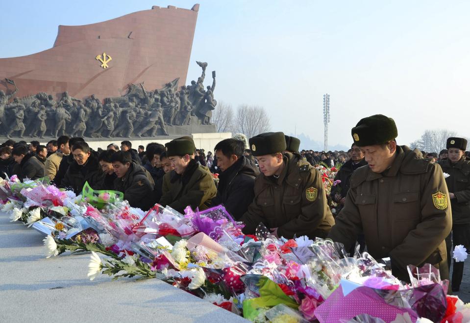 North Koreans offer flowers in front of statues of North Korea's founder Kim Il Sung and former leader Kim Jong Il at Mansudae hill in Pyongyang