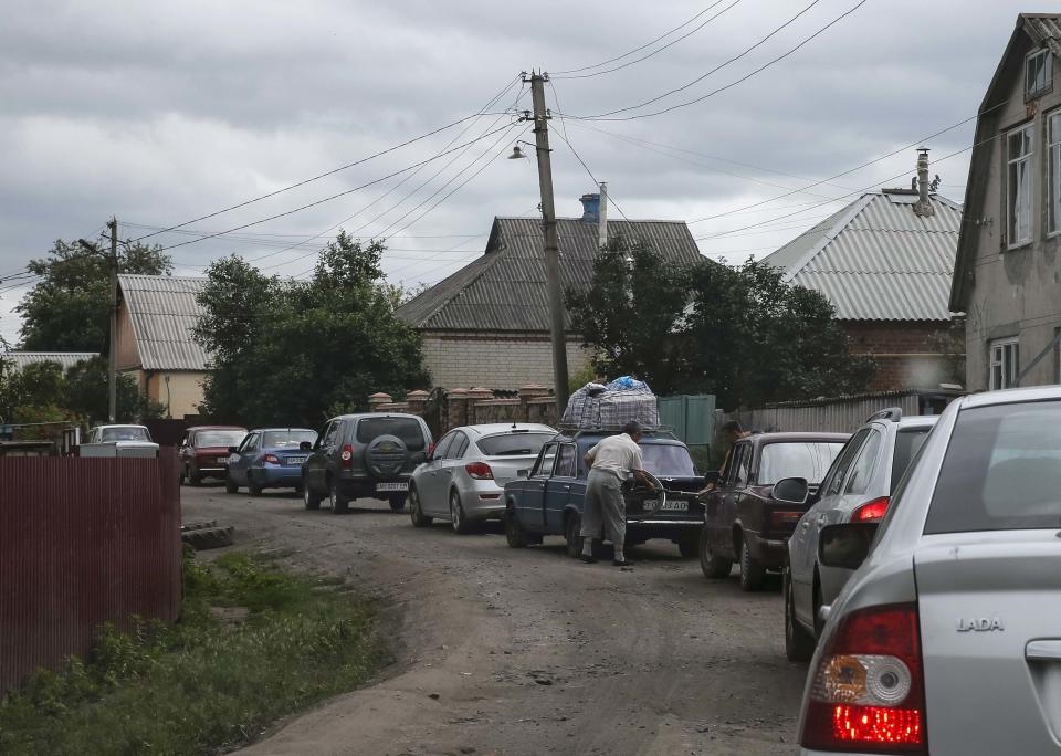 Local residents fleeing from the fighting in eastern Ukraine are seen in a line of cars near the town of Slaviansk June 12, 2014. Ukraine's new president signaled on Wednesday he would be ready to hold talks with opponents in eastern Ukraine if pro-Russian separatists waging an insurgency there agreed to lay down their weapons. REUTERS/Gleb Garanich (UKRAINE - Tags: POLITICS CIVIL UNREST)