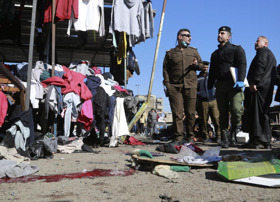 Security forces work at the site of a deadly bomb attack in a market selling used clothes, Iraq, Thursday, Jan. 21, 2021. Iraq's military said twin suicide bombings have ripped through a busy market in Iraq’s capital, killing over 2 dozen and wounding over 70 with some in serious condition. (AP Photo/Hadi Mizban)