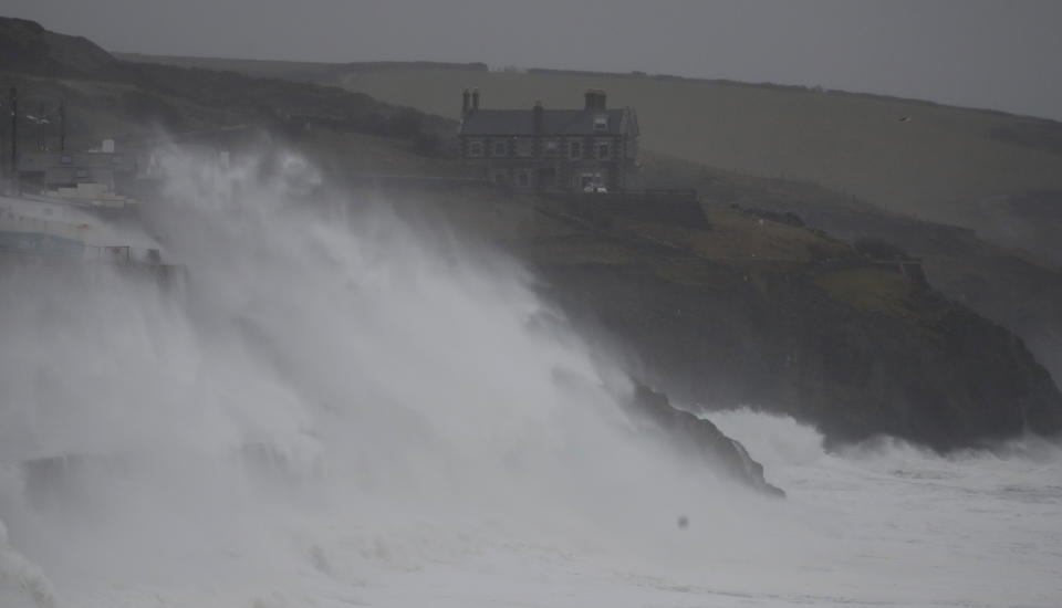 Powerful waves break on the shoreline around the small port of Porthleven, south west England, Sunday, Feb. 16, 2020. Storm Dennis roared across Britain on Sunday, lashing towns and cities with high winds and dumping so much rain that authorities urged residents to protect themselves from "life-threatening floods" in Wales and Scotland. (AP Photo/Alastair Grant)