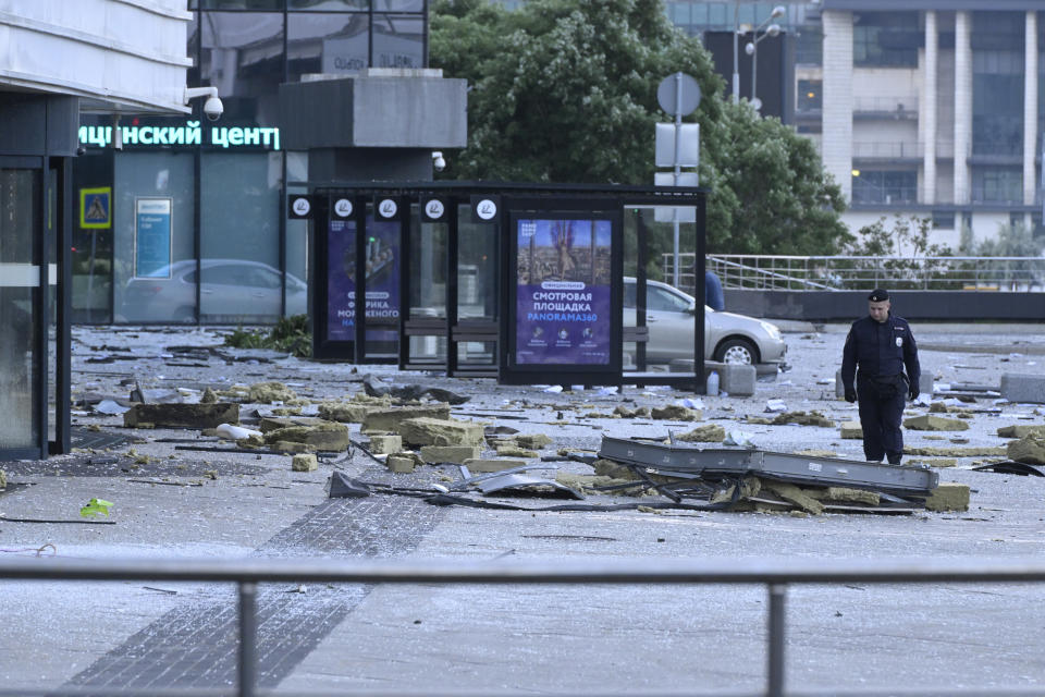 An investigator examines an area next to the damaged skyscraper in the "Moscow City" business district after a reported drone attack in Moscow, Russia, early Sunday, July 30, 2023. (AP Photo)