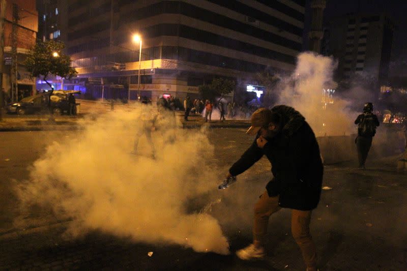 A demonstrator extinguishes a tear gas during a protest against the lockdown and worsening economic conditions, amid the spread of the coronavirus disease (COVID-19), in Tripoli