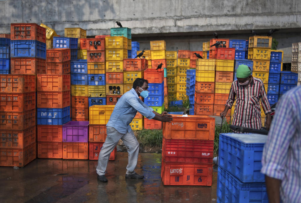 People wearing masks as a precaution against the coronavirus work at a fish market in Kochi, Kerala state, India, Thursday, April 22, 2021. India reported a global record of more than 314,000 new infections Thursday as a grim coronavirus surge in the world's second-most populous country sends more and more sick people into a fragile health care system critically short of hospital beds and oxygen. (AP Photo/R S Iyer)