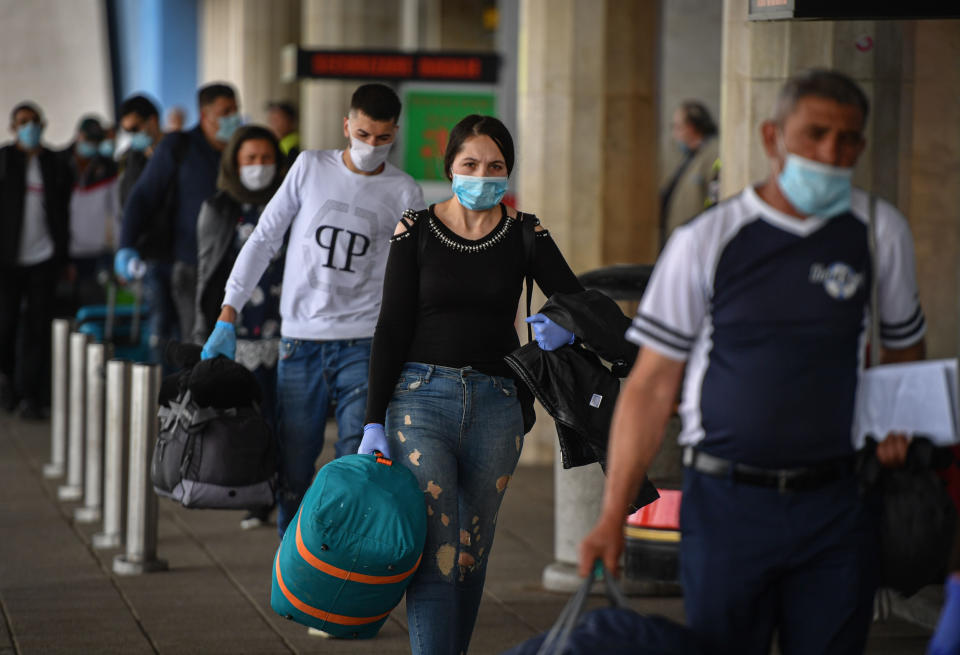 Image: Romanian harvest workers heading to the U.K. wait in line to enter the airport in Bucharest (Daniel Mihailescu / AFP - Getty Images)