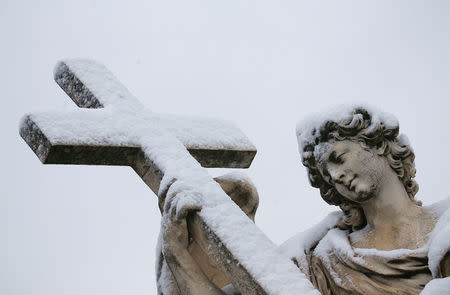 A statue is seen covered in snow during a heavy snowfall in Rome. REUTERS/Alessandro Bianchi