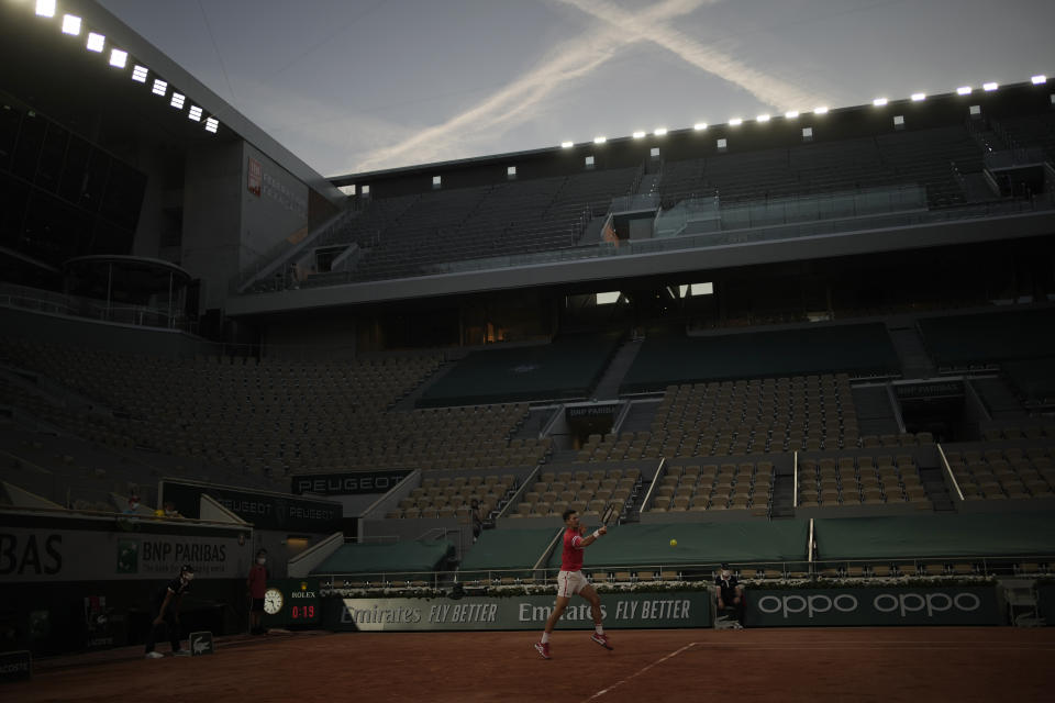 El serbio Novak Djokovic hace una devolución al estadounidense Tenys Sandgren en la primera ronda del Abierto de Francia, el martes 1 de junio de 2021, en París (AP Foto/Christophe Ena)