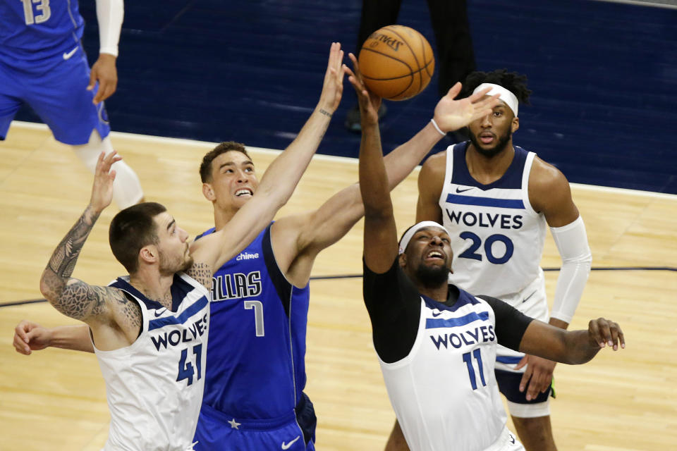 Dallas Mavericks center Dwight Powell (7) battles for a rebound against Minnesota Timberwolves center Naz Reid (11) and forward Juancho Hernangomez (41) in the first quarter during an NBA basketball game, Sunday, May 16, 2021, in Minneapolis. (AP Photo/Andy Clayton-King)
