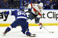 Florida Panthers left wing Jonathan Huberdeau (11) gets off a shot in front of Tampa Bay Lightning defenseman Mikhail Sergachev (98) during the first period in Game 6 of an NHL hockey Stanley Cup first-round playoff series Wednesday, May 26, 2021, in Tampa, Fla. (AP Photo/Chris O'Meara)